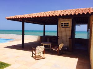 a gazebo with a table and chairs and the beach at Casa em Condomínio Barra São Miguel in Barra de São Miguel