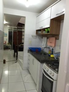 a kitchen with a sink and a stove top oven at Casa em Condomínio Barra São Miguel in Barra de São Miguel