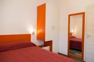 カーポ・ヴァチカーノにあるMarinella Beach Apartmentのベッド2台と鏡が備わるホテルルームです。