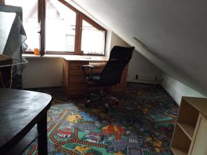 グディニャにある1st Floor Open'er Roomの机と椅子が敷物に掛けられた部屋