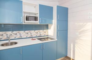 カーポ・ヴァチカーノにあるMarinella Beach Apartmentの青いキッチン(シンク、電子レンジ付)