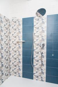 bagno con doccia e piastrelle blu di Marinella Beach Apartment a Capo Vaticano