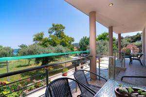 a balcony with tables and chairs and a view at Kapsogeorgis Rooms in Koinyra