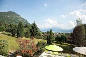 a garden with umbrellas and a view of the mountains at Centre Jean XXIII in Annecy