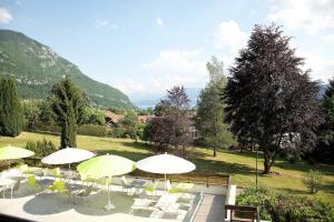 een patio met tafels, stoelen en parasols bij Centre Jean XXIII in Annecy