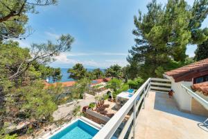 a villa with a swimming pool and a balcony at Apartments Tamar in Jelsa
