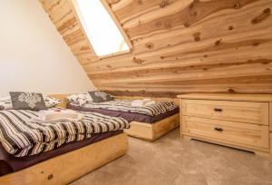 2 Betten in einem Zimmer mit Holzwänden in der Unterkunft Apartamenty Kiry Zakopane in Kościelisko