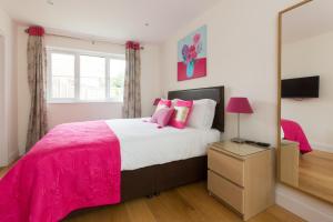 a bedroom with a large bed and a mirror at 2 Suffolk Cottage, Knodishall in Aldringham