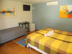 a hotel room with two beds and a table at Pousada Temperança in Beberibe