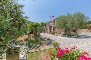 a garden with flowers and a house in the background at Apartments Mirjana in Vrsar