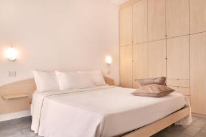 una camera da letto con un grande letto bianco con cuscini bianchi di Residence Domaso a Domaso