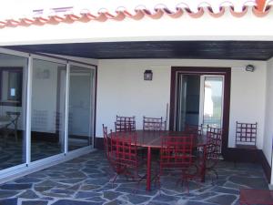 un patio con sillas rojas y una mesa en el balcón en Agro-Turismo Herdade do Carneiro, en Escoural