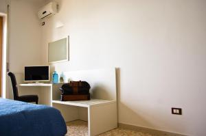 a room with a bed and a desk with a computer at Terrazza Marconi in Salerno