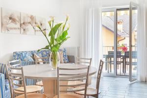 una sala da pranzo con tavolo e vaso di fiori di Residence Domaso a Domaso
