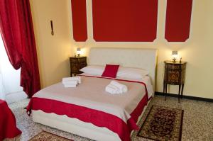 um quarto com uma cama com paredes vermelhas e duas mesas em Affittacamere "Angel 2" em La Spezia