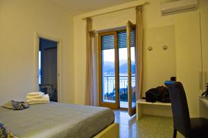 Schlafzimmer mit einem Bett und einer Tür zu einem Balkon in der Unterkunft Terrazza Marconi in Salerno