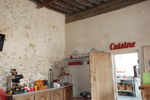 a kitchen with a wall covered in china at Ferme du Grand Hotel du Bois in Jouarre