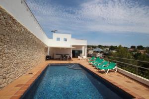 una casa con piscina y algunas sillas y un edificio en Elena Baladrar - sea view villa with private pool in Benissa, en Benissa