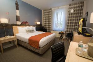 um quarto de hotel com uma cama e um farol em Adria Hotel and Conference Center em Queens