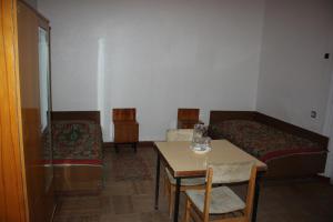 a room with a bed and a table and chairs at Firuza Hostel in Borjomi