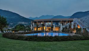 a large house with a swimming pool in front of it at Tullio Hotel in Gravedona