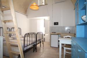 een kamer met 2 stapelbedden en een keuken bij Appartamento la Corte Azzurra in Alliste