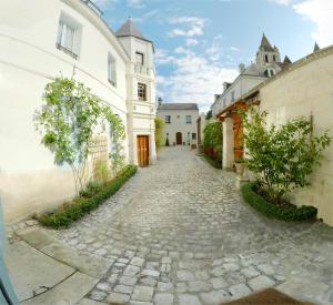 een geplaveide straat in een stad met witte gebouwen bij Le Gite du Chevalier in Loches