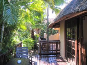 a porch of a house with a table and chairs at Afrikhaya Guest House in St Lucia