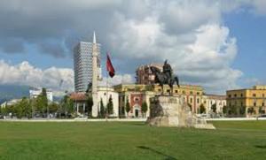 a building with a statue in the middle of a field at Hotel Austria in Tirana