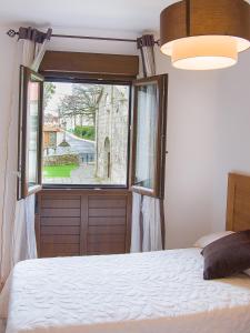 a bedroom with a bed and a window with a view at Pension Rustica Casa Do relojero in Zas