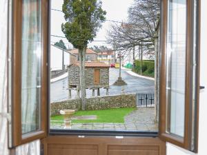 una ventana abierta con vistas a la calle en Pension Rustica Casa Do relojero, en Zas