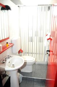 a bathroom with a white toilet and a sink at Il Gatto e La Volpe in Venetico