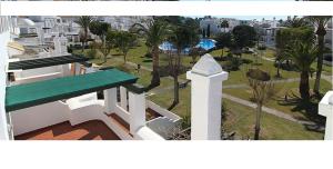サアラ・デ・ロス・アトゥネスにあるESTUDIO EN ZAHARA piscina y acceso a playaの緑のベンチ付きの建物から公園を望めます。
