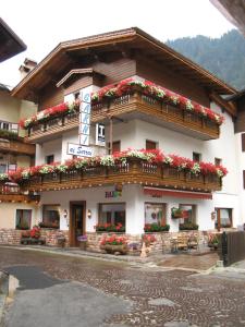 a building with flower boxes on the front of it at Hotel Garnì Ai Serrai in Rocca Pietore
