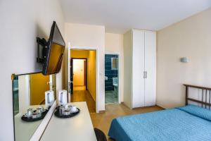 Habitación con cama y escritorio con TV. en Vega Apartments, en Limassol