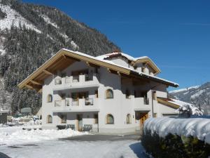 un gran edificio blanco con nieve en el suelo en Villa Amsel, en Mayrhofen