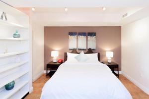 a bedroom with a large white bed and two lamps at Chelsea Pines Inn in New York