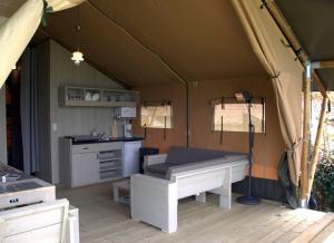 a tent with a bed and a kitchen in it at Glamping op het Zeugekot in Beveren