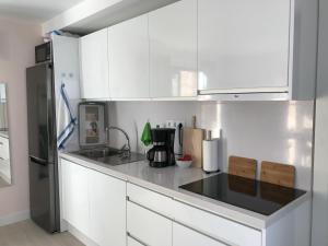 a kitchen with white cabinets and a black appliance at Vivienda Vacacional Casa Federico in Corralejo