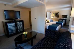 a hotel room with two beds and a couch and a tv at Warwick Allerton Chicago in Chicago