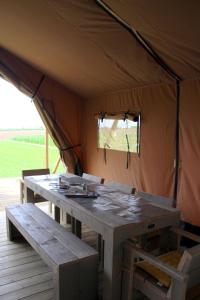 tenda con tavolo in legno e panche di Glamping op het Zeugekot a Beveren Altre 25 foto