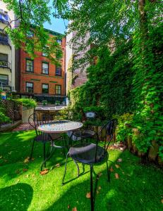 a patio with a table and chairs in the grass at Chelsea Pines Inn in New York