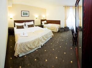 Un pat sau paturi într-o cameră la Hotel & Apartments U Černého orla