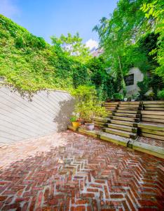 a brick walkway with two potted plants and stairs at Chelsea Pines Inn in New York