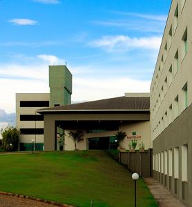 a building with a green lawn in front of it at Hotel Mirante São Brás in São Brás do Suaçuí