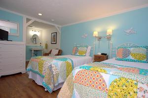 1 Schlafzimmer mit 2 Betten und blauen Wänden in der Unterkunft Long Dell Inn in Centerville