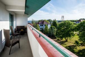 a balcony with chairs and a view of a yard at Apartament U Virusa Przy Porcie z widokiem na jezioro in Giżycko