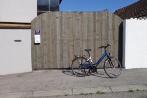 uma bicicleta estacionada em frente a uma cerca de madeira em Gasthaus Helena em Mörbisch am See