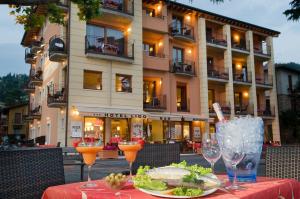 - une table avec une assiette de nourriture et des verres à vin dans l'établissement Hotel Lido, à Torri del Benaco