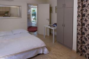 a bedroom with a bed and a table and a window at Pinat Nofesh in Rosh Pinna